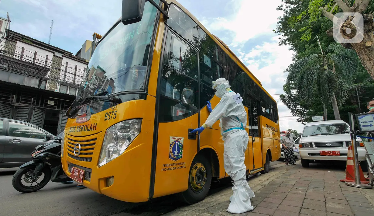 Petugas mengenakan APD saat akan mengantarkan pasien COVID-19 menuju RSDC Wisma Atlet di Puskesmas Kecamatan Tebet, Jakarta, Kamis (3/2/2022). Kasus COVID-19 sepekan terakhir mencapai 56.000 atau meningkat 40 kali lipat dibandingkan awal Januari lalu. (Liputan6.com/Herman Zakharia)