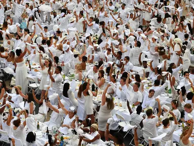 Ribuan orang berpakaian serba putih berkumpul dalam Diner en blanc (Dinner in White) di alun-alun Lincoln Center, New York, Selasa (22/8). Pada makan malam ini seluruh peserta mengusung tema putih dalam berbusana dan peralatan makan (TIMOTHY A. CLARY/AFP)