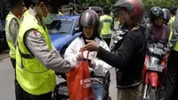 Seorang polisi memeriksa isi barang bawaan pengendara motor yang melintas saat gelar Operasi Cipta Kondisi di Surabaya, Jatim. (Antara)