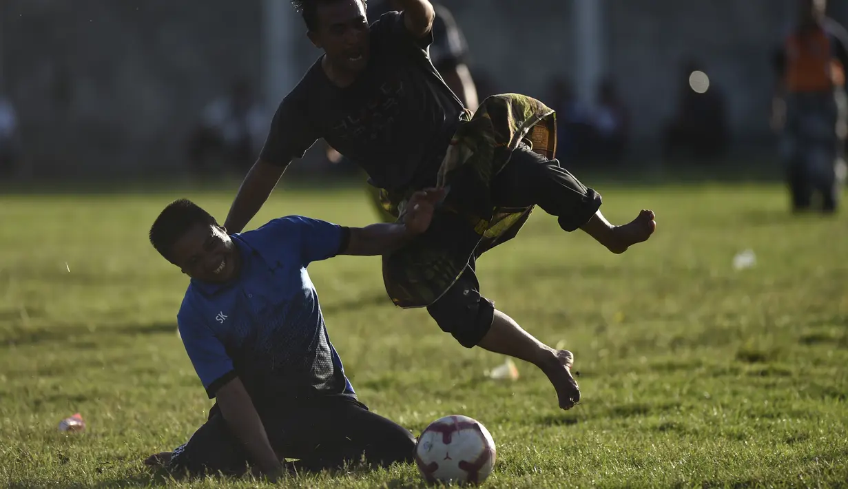 Penduduk desa bermain sepak bola dengan mengenakan sarung saat merayakan HUT ke-74 RI di Blang Pidie provinsi Aceh (17/8/2019). Indonesia merayakan kemerdekaan yang ke-74 dari pemerintahan kolonial Belanda. (AFP Photo/Chaideer Mahyuddin)