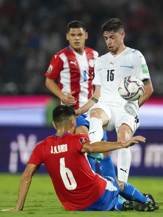 Pemain Uruguay Federico Valverde (15) berebut bola dengan pemain Paraguay Junior Alonso (6) pada pertandingan sepak bola kualifikasi Piala Dunia 2022 di Stadion General Pablo Rojas, Asuncion, Paraguay, 27 Januari 2022. Uruguay menang 1-0. (AP Photo/Jorge Saenz)
