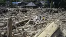 Warga desa memotong kayu-kayu yang hanyut oleh banjir bandang di Garoga, Provinsi Sumatera Utara, pada Kamis 4 Desember 2025. Banjir bandang di Desa Aek Garoga, Kecamatan Batang Toru, Tapanuli Selatan, Sumatera Utara, yang terjadi pada akhir November 2025 lalu membawa serta kayu-kayu gelondongan dalam jumlah besar. (YT HARIONO/AFP)
