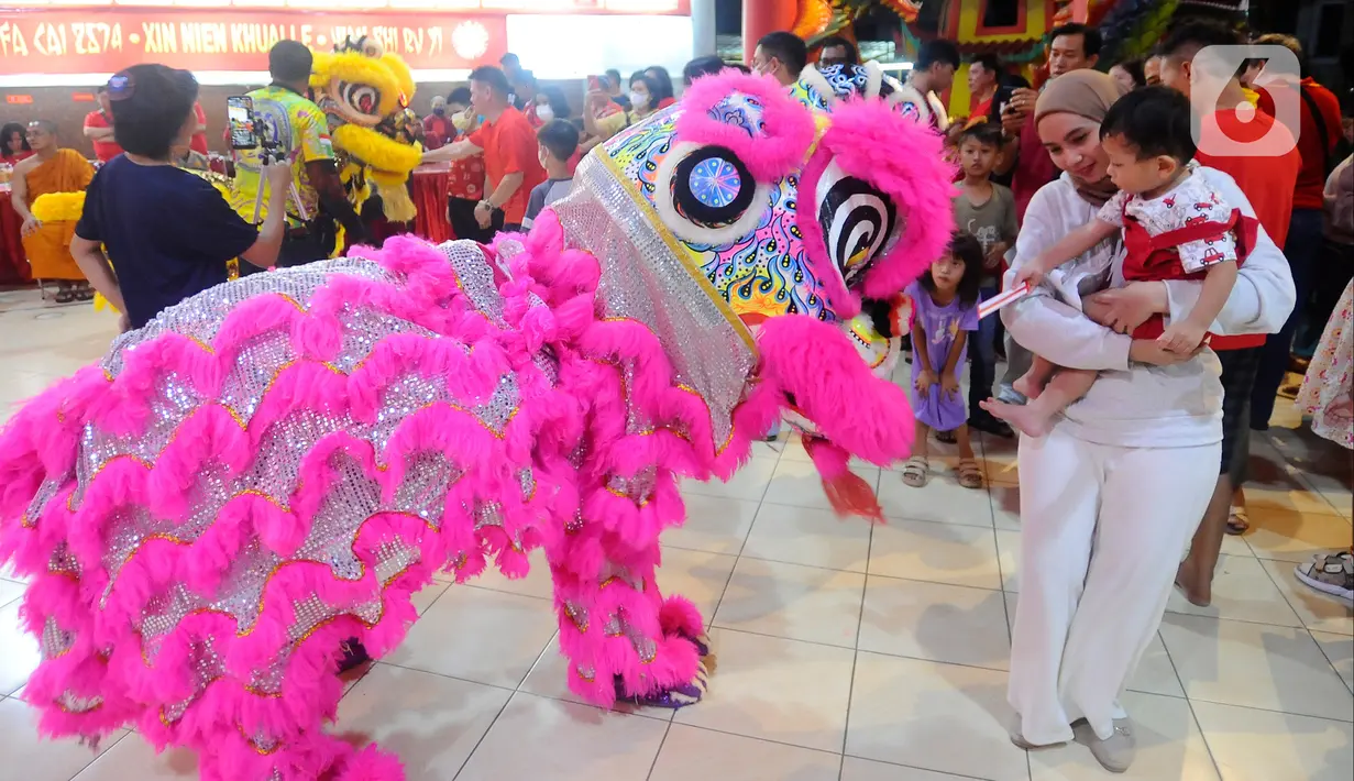 Warga memberikan angpao kepada barongsai saat perayaan malam Tahun Baru Imlek 2574 di Vihara Kwan In Thang, Pondok Cabe, Tangerang Selatan, Banten, Sabtu (21/1/2023). Perayaan Imlek berlangsung semarak dengan adanya pertunjukan barongsai setelah sempat vakum selama 2 tahun akibat pandemi Covid-19. (merdeka.com/Arie Basuki)