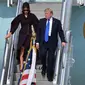 Presiden AS Donald Trump bersama istrinya Ibu Negara Melania saat menuruni tangga pesawat saat tiba di Pangkalan Udara Osan, Pyeongtaek, Korea Selatan, (7/11). (AFP Photo/Song Kyung-Seok)