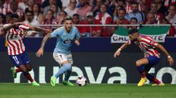 Pemain Atletico Madrid Thomas Lemar (kiri) berebut bola dengan pemain Celta Vigo Carles Perez (tengah) pada pertandingan sepak bola Liga Spanyol di Stadion Wanda Metropolitano, Madrid, Spanyol, 10 September 2022. Atletico Madrid menang 4-1. (Thomas COEX/AFP)