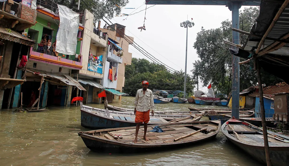 Selain menewaskan sekitar 300 jiwa, banjir bandang di India juga menenggelamkan jalan sehingga warga menggunakan perahu sebagai moda transportasi, Allahabad, India (26/8). (REUTERS/Jitendra Prakash)