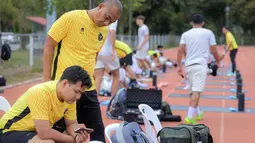 Selain Sumardji, asisten pelatih Timnas Indonesia U-22, Eko Purdjianto, juga menyaksikan laga Timnas Vietnam U-22 vs Timnas Malaysia U-22 dari layar handphone. (Bola.com/Bagaskara Lazuardi)