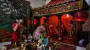 Pembersihan dilakukan dengan sangat hati-hati menggunakan kain lembut untuk menjangkau lekukan detail pada patung. Tampak dalam foto, para sukarelawan membersihkan patung-patung dewa di Kuil Hong San Ko Tee, Surabaya, Jawa Timur, pada Rabu 11 Februari 2026. (JUNI KRISWANTO/AFP)