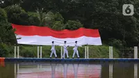 Anggota Paskibraka bersiap mengibarkan bendera merah putih di Sungai Cisadane, Kota Tangerang, Banten, Kamis (28/10/2021). Pengibaran bendera merah putih yang di ikuti puluhan pemuda tersebut di lakukan untuk memperingati hari sumpah pemuda. (Liputan6.com/Angga Yuniar)