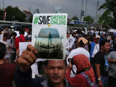 Seorang driver online memperlihatkan poster yang berisi tuntutannya saat unjuk rasa di depan DPR, Jakarta, Senin (22/8). Aksi tersebut untuk penolakan Peraturan Menteri Perhubungan (Permenhub) No 32 Tahun 3016. (Liputan6.com/Angga Yuniar)