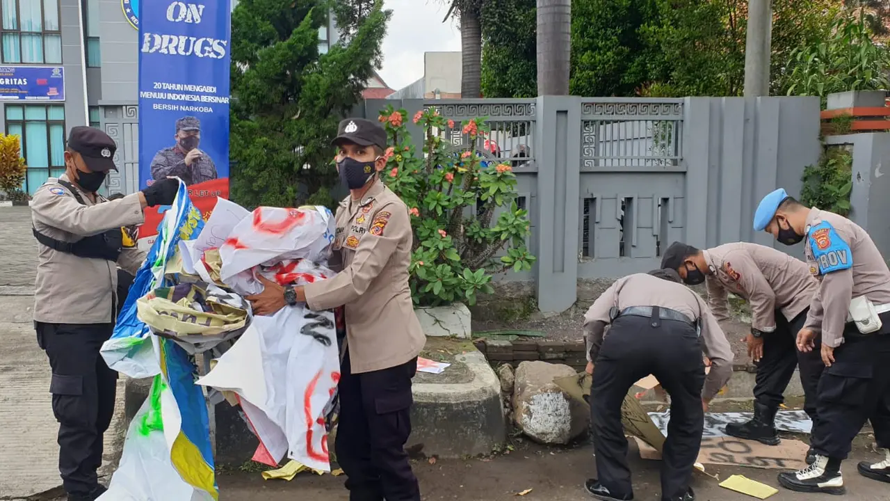 Beberapa anggota Polres Garut nampak sigap melaksanakan pembersihan sampah di lokasi bekas aksi demo mahasiswa 11 April depan gedung DPRD Garut.