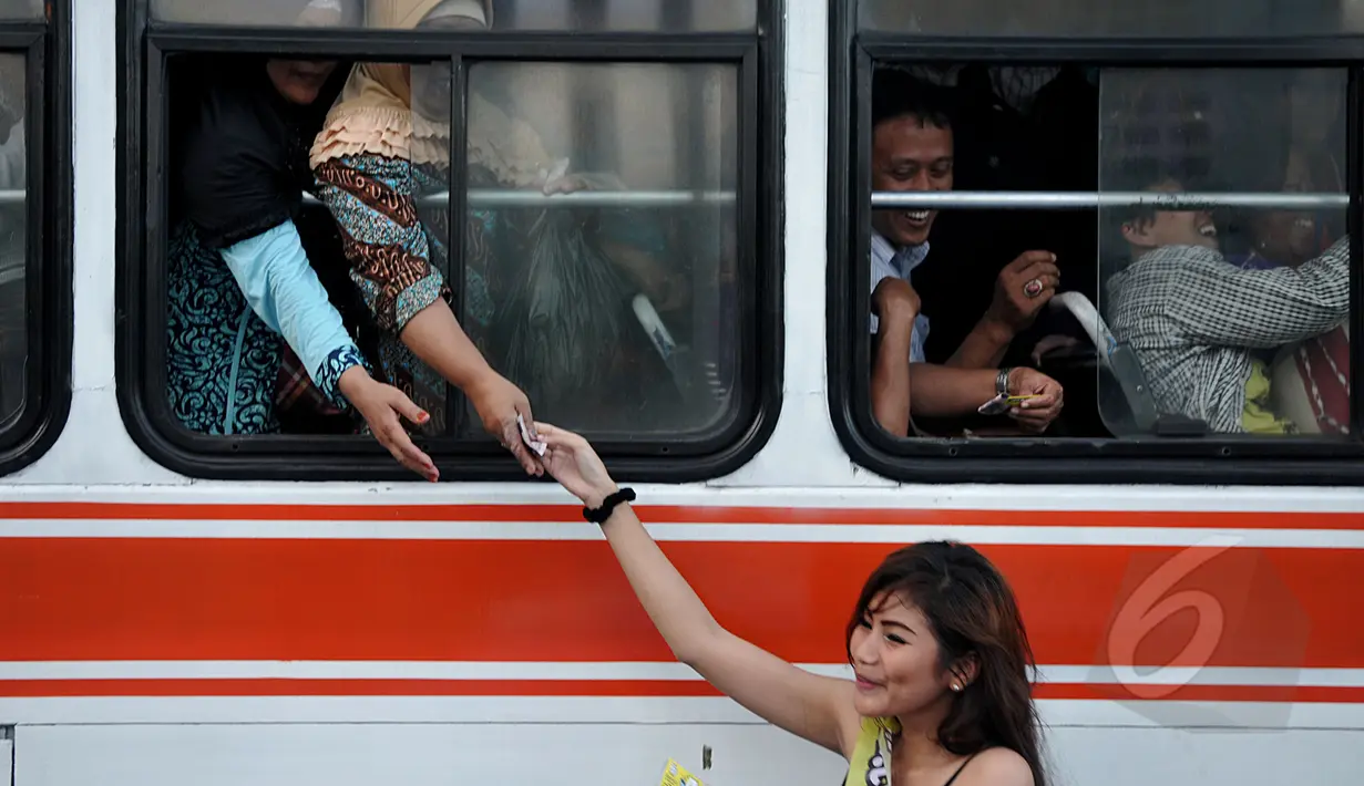 Warga yang berada di dalam bus juga mendapat uang dari para wanita cantik di Bundaran HI, Jakarta, Kamis (9/4/2015).  Kegiatan tersebut dalam rangka sosialisasi peluncuran sebuah aplikasi game online (Liputan6.com/Johan Tallo).