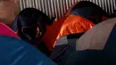 Seorang wanita imigran duduk di tenda tempat penampungan di Tijuana, Meksiko 6 April 2019. Rombongan migran Amerika Tengah mencapai kota perbatasan antara Meksiko dan AS tersebut  untuk mencari suaka akibat kekerasan, pembunuhan dan kemiskinan yang mengancam mereka. (REUTERS/Carlos Jasso)