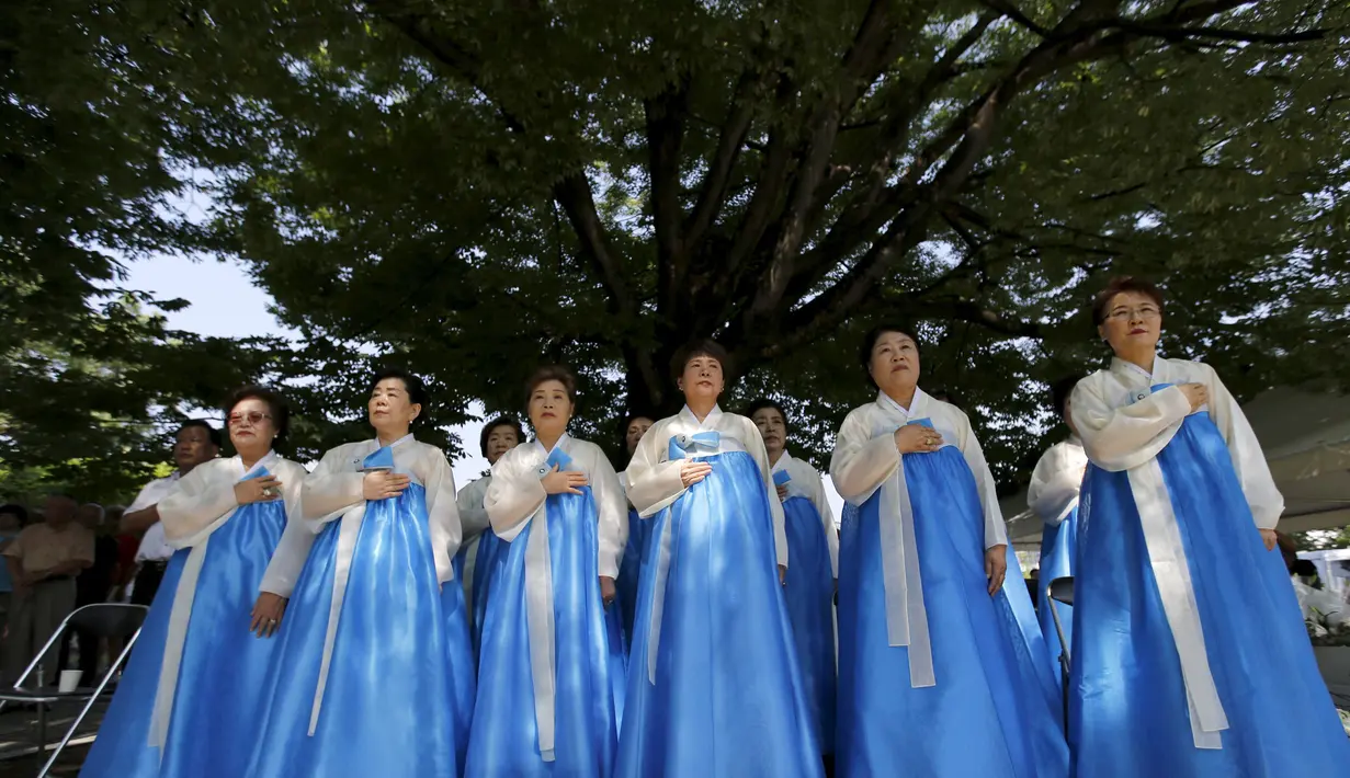 Sejumlah Wanita sedang  mendengarkan lagu kebangsaan yang didedikasikan untuk memperingati 70 tahun  serangan bom Hiroshima, Jepang, Rabu  (5/8/2015).  Jepang akan memperingati jatuhnya bom  Hiroshima pada 6 Agustus 1945.  (REUTERS/Toru Hanai)