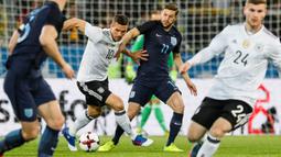 Gelandang Jerman, Lukas Podolski, berusaha melewati Gelandang Inggris, Adam Lallana. Meski pensiun dari Jerman, Podolski masih melanjutkan kariernya di level klub. (EPA/Ronald Wittek)