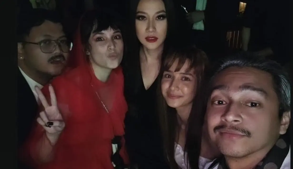 Bunga Citra Lestari tampil dengan dress hitam panjang v neck dengan tatanan rambut panjang belah tengah, ia tampil mirip seperti Morticia addams. @mikhatambayong.