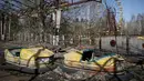 Dua mainan mobil terlihat di taman bermain yang terbengkalai di kota Pripyat yang ditinggalkan penduduknya, dekat pembangkit tenaga nuklir, Ukraina, 28 Maret 2016. (REUTERS/Gleb Garanich)