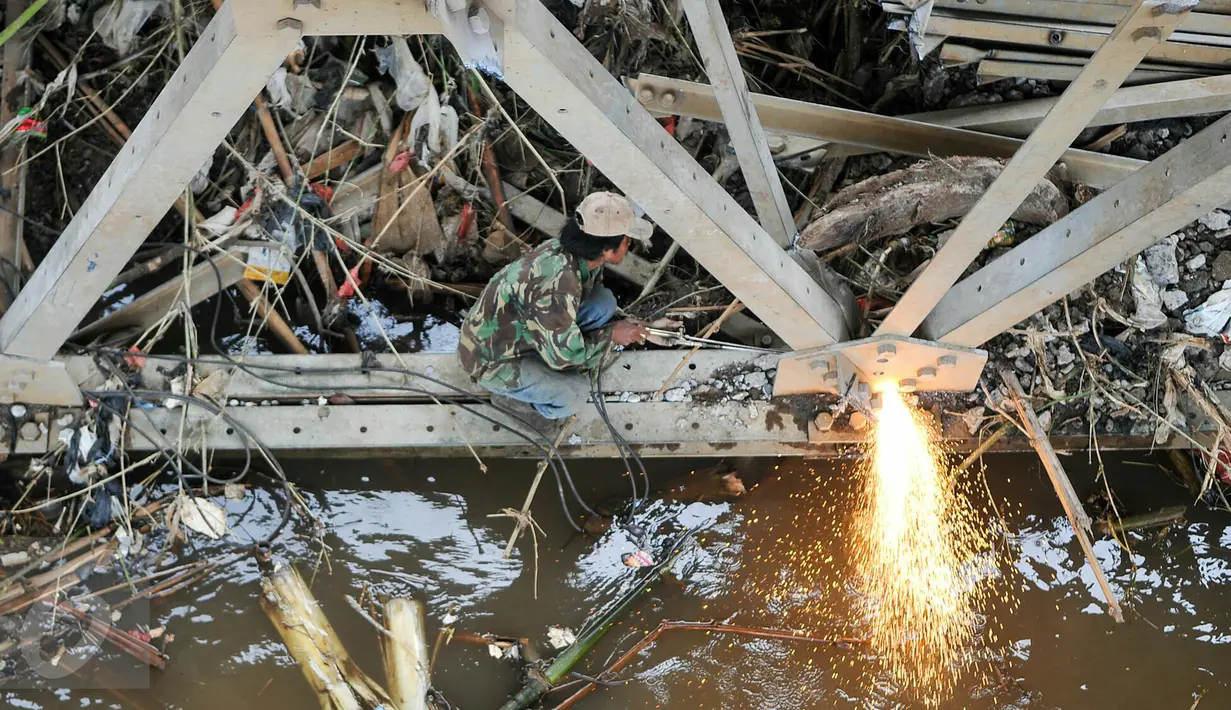 Petugas mengelas besi pondasi jembatan Rawajati untuk mempermudah pembongkaran, Jakarta, Selasa (15/3). Gubernur DKI Basuki Tjahaja Purnama meminta Dinas PU segera membongkar Jembatan tersebut karena menjadi penyebab banjir. (Liputan6.com/Yoppy Renato)