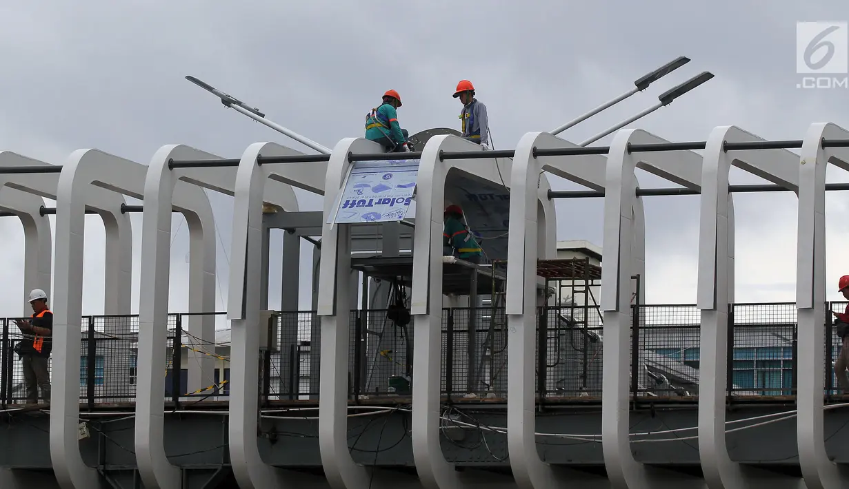 Pekerja melakukan pengerjaan revitalisasi Jembatan Penyeberangan Orang (JPO) Ratu Plaza, Jakarta, Jumat (28/12). JPO Ratu Plaza masuk dalam proses revitalisasi dan ditargetkan selesai pada akhir Desember 2018. (Liputan6.com/JohanTallo)