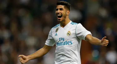 Pemain Real Madrid, Marco Asensio berselebrasi setelah mencetak gol ke gawang Eibar dalam lanjutan La Liga pekan kesembilan di Stadion Santiago Bernabeu, Minggu (22/10). Madrid menang tiga gol tanpa balas. (AP/Francisco Seco)