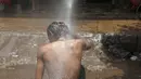 Seorang pria mendinginkan tubuhnya di bawah guyuran air saat cuaca panas yang ekstrem di Karachi, Pakistan, (23/6/2015). Gelombang panas yang telah menewaskan lebih dari 400 jiwa di kota selatan Pakistan. (REUTERS/Akhtar Soomro)