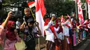 Masyarakat menyaksikan proses kirab budaya di sepanjang area Monumen Nasional (Monas) di Jakarta, Kamis (17/8/2023). Pasukan kirab sendiri diikuti peserta dari beragam elemen masyarakat, mulai pelajar hingga ibu-ibu berkebaya. (Liputan6.com/Angga Yuniar)