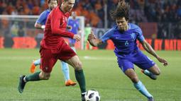Bintang Portugal, Cristiano Ronaldo, berusaha melewati bek Belanda, Nathan Ake, pada laga persahabatan di Stade de Geneve, Swiss, Senin (26/3/2018). Portugal kalah 0-3 dari Belanda. (AP/Salvatore Di Nolfi)