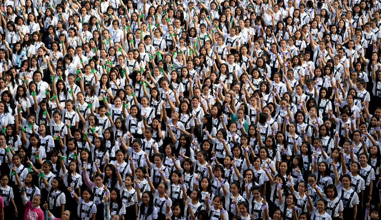 Ribuan siswa St. Scholastica College mengacungkan jari telunjuk "nomor satu" saat menari massal dalam aksi One Billion Rising di Filipina, Senin (15/2). Gerakan ini bentuk kampanye untuk menghentikan kekerasan terhadap perempuan. (AFP PHOTO/Noel CELIS)