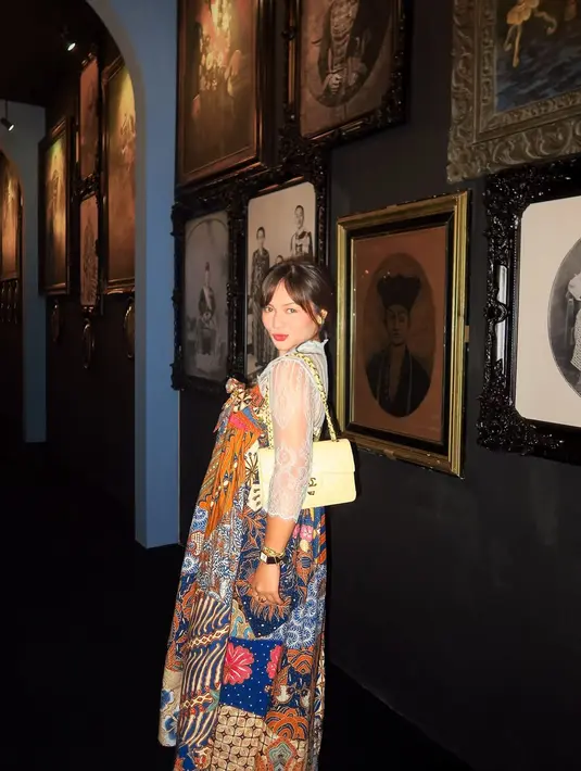 Bukan kebaya sebagai luaran, melainkan sebaliknya, Amel tampil berani mengenakan dress batik colorful di atas kebaya brokat tipis berwarna biru muda. [@amelcarla].