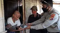 Foto: Kapolsek Nita, Ipda Valentinus Tani, saat menyerahkan bantuan meteran listrik yang disisihkan dari gaji anggotanya, Bripka Yohanes (Liputan6.com/Dion)