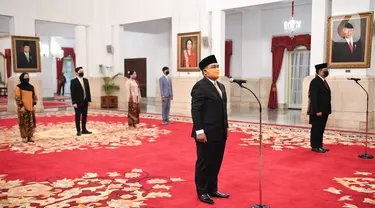 Kepala Badan Pelindungan Pekerja Migran Indonesia (BP2MI) Benny Rhamdani (kiri) dan Komisioner KPU I Dewa Kade Wiarsa Raka Sandi mengikuti pelantikan di Istana Negara, Jakarta, Rabu (15/4/2020). (Antarafoto/Hafidz Mubarak/Pool)