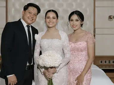 Dalam unggahan terbaru Yunita Siregar di Instagram pribadinya, Yunita Siregar tampak anggun mengenakan gaun pernikahan berwarna putih dengan detail elegan. Sang kakak dengan penuh kebanggaan menemani adiknya dalam momen bahagia pernikahan ini. Keduanya terlihat tersenyum hangat, mencerminkan hubungan kakak beradik yang begitu erat. (Liputan6.com/IG/@yunitasiregar)