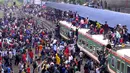 Ratusan orang berupaya menaiki atap kereta api untuk menuju kampung halaman di Dhaka, Bangladesh pada 4 Juni 2019. Pemadangan mencengangkan dari ratusan yang naik dan duduk di atas kereta karena gerbong yang penuh terlihat pada menjelang Idul Fitri di Bangladesh. (MUNIR UZ ZAMAN/AFP)