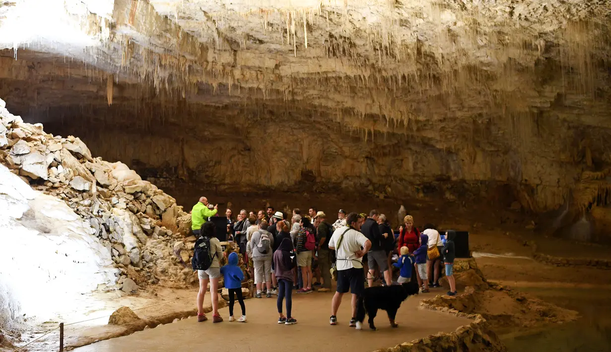 Pengunjung berada di dalam gua alam Choranche, di wilayah Vercors dekat Grenoble, Prancis (3/8). Sejak dimulainya gelombang panas, telah terjadi peningkatan setidaknya 10 persen jumlah pengunjung gua. (AFP Photo/Jean-Pierre Clatot)