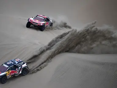 Pembalap Spanyol, Carlos Sainz dan asisten pengemudi Lucas Cruz (kiri) serta pembalap Prancis Cyril Despres dan asisten pengemudi David Castera bersaing dalam Reli Dakar 2018 di Pisco, Peru, (7/1). (Franck FIFE/AFP)