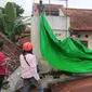 Personel BPBD Kota Batu bersama relawan dan warga memasang terpal penahan air di lokasi bencana tanah ambles agar tak meluas di rumah warga Sisir, Kota Batu (Foto : BPBD Kota Batu)