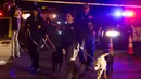 Polisi membawa anjing pelacak di lokasi ledakan di Austin, Texas (18/3). Area di sekitar lokasi ledakan telah diblokir dan otoritas mewawancarai tetangga dan mencari saksi. (Nick Wagner / Austin American-Statesman via AP)