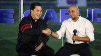 Ketua Umum PSSI, Erick Thohir (kiri) berjabat tangan dengan legenda sepak bola Brasil, Roberto Carlos saat kegiatan BRImo Future Garuda di Lapangan BRILiaN Stadium, Jalan Fatmawati Raya, Jakarta, Selasa (30/05/2023). (Bola.com/Bagaskara Lazuardi)