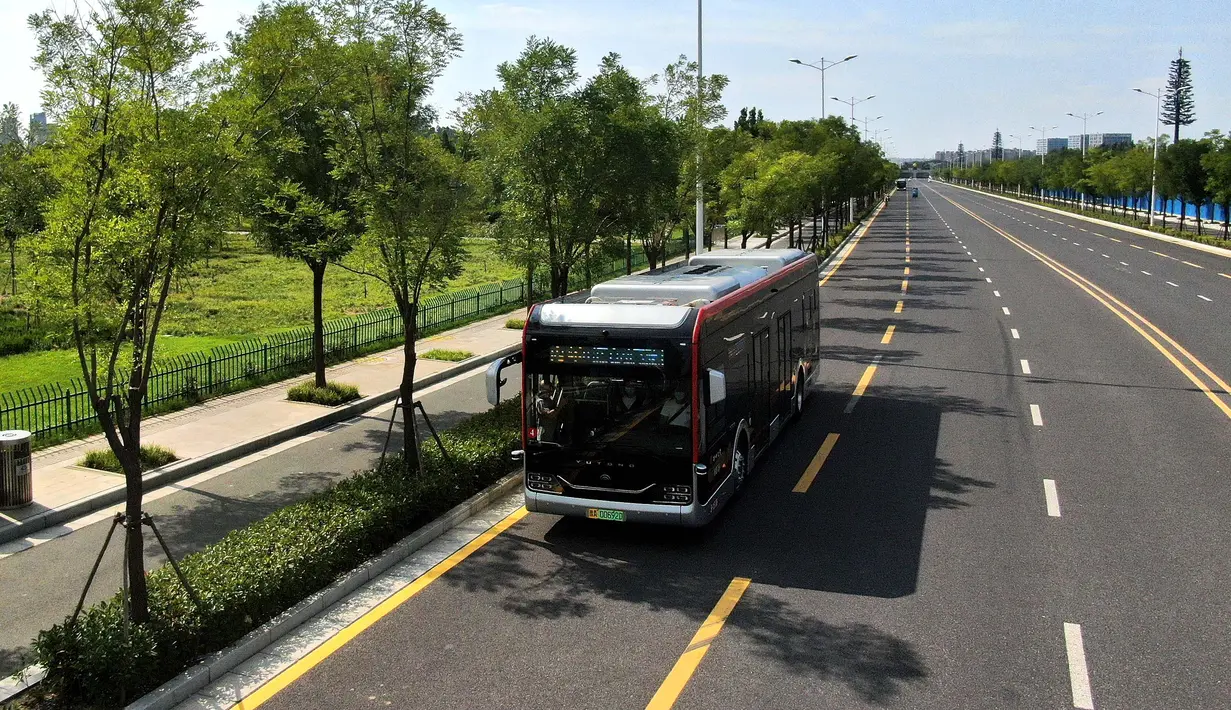 Foto udara menunjukkan sebuah bus otonomos dari jalur bus autopilot 1 melintas di Zhengzhou, Provinsi Henan, China (18/8/2020). Bus autopilot ini menggabungkan sejumlah teknologi seperti layanan jaringan 5G dan kecerdasan buatan (AI) serta sistem pengawasan dan kendali cerdas. (Xinhua/Li An)