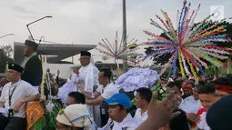 Cawapres 01 Ma'ruf Amin menaiki kereta kencana usai 'Konser Putih Bersatu' di Stadion Gelora Bung Karno (SGBK), Jakarta, Sabtu (13/4). Pasangan Capres dan Cawapres 01 menggunakan kereta kencana seusai Konser Putih Bersatu menuju lokasi debat. (Liputan6.com/Herman Zakharia)