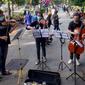 Musisi lokal Bogor memainkan musik klasik di pedestrian Kebun Raya, Jalan Pajajaran, Bogor, Jawa Barat, Minggu (14/6/2020). Untuk memenuhi kebutuhan hidup akibat sepinya job pertunjukan selama pandemi COVID-19, mereka memilih mengamen saat warga berolahraga. (merdeka.com/Arie Basuki)