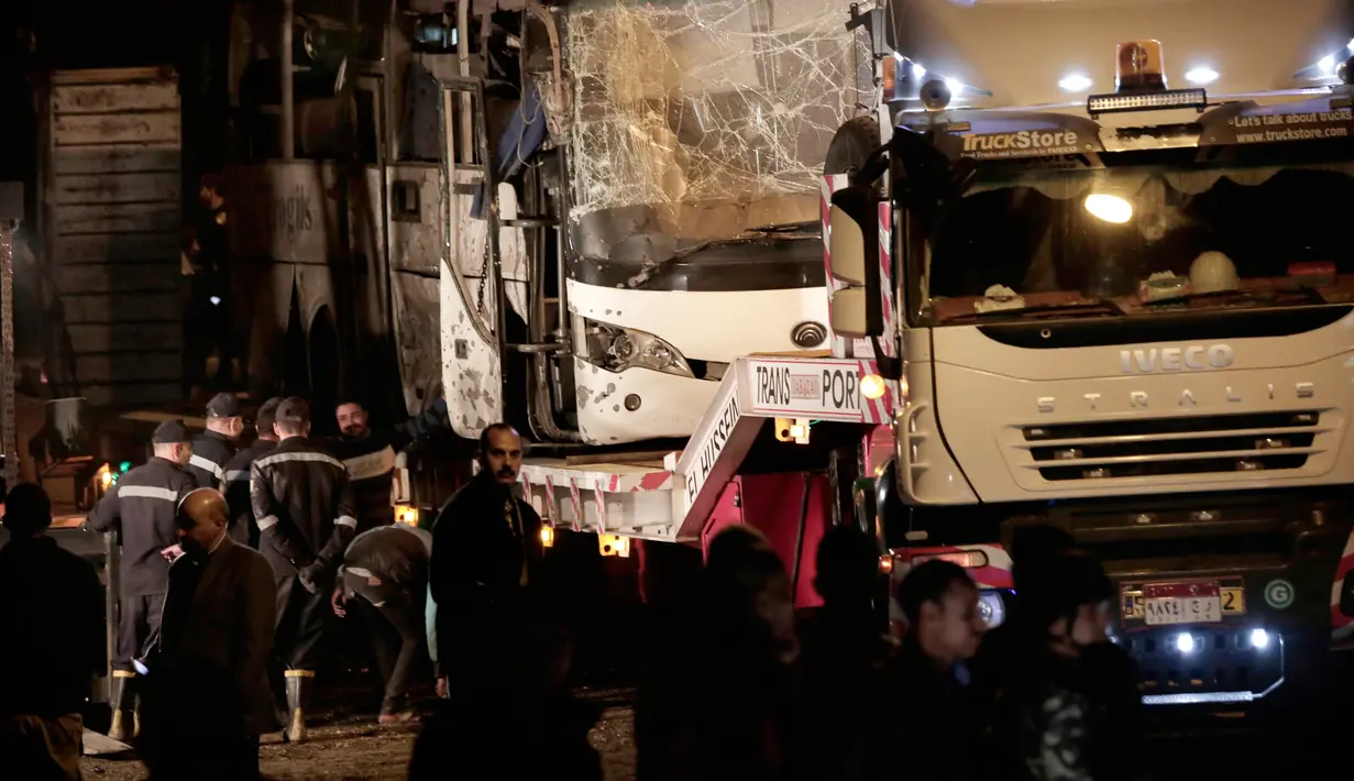 Petugas membawa sebuah bus wisata setelah sebuah bom pinggir jalan di sebuah daerah dekat Piramida Giza di Kairo, Mesir (28/12). Bus itu membawa 16 orang, terdiri dari 14 wisatawan Vietnam, seorang pengemudi dan pemandu wisata. (AP Photo/Nariman El-Mofty)