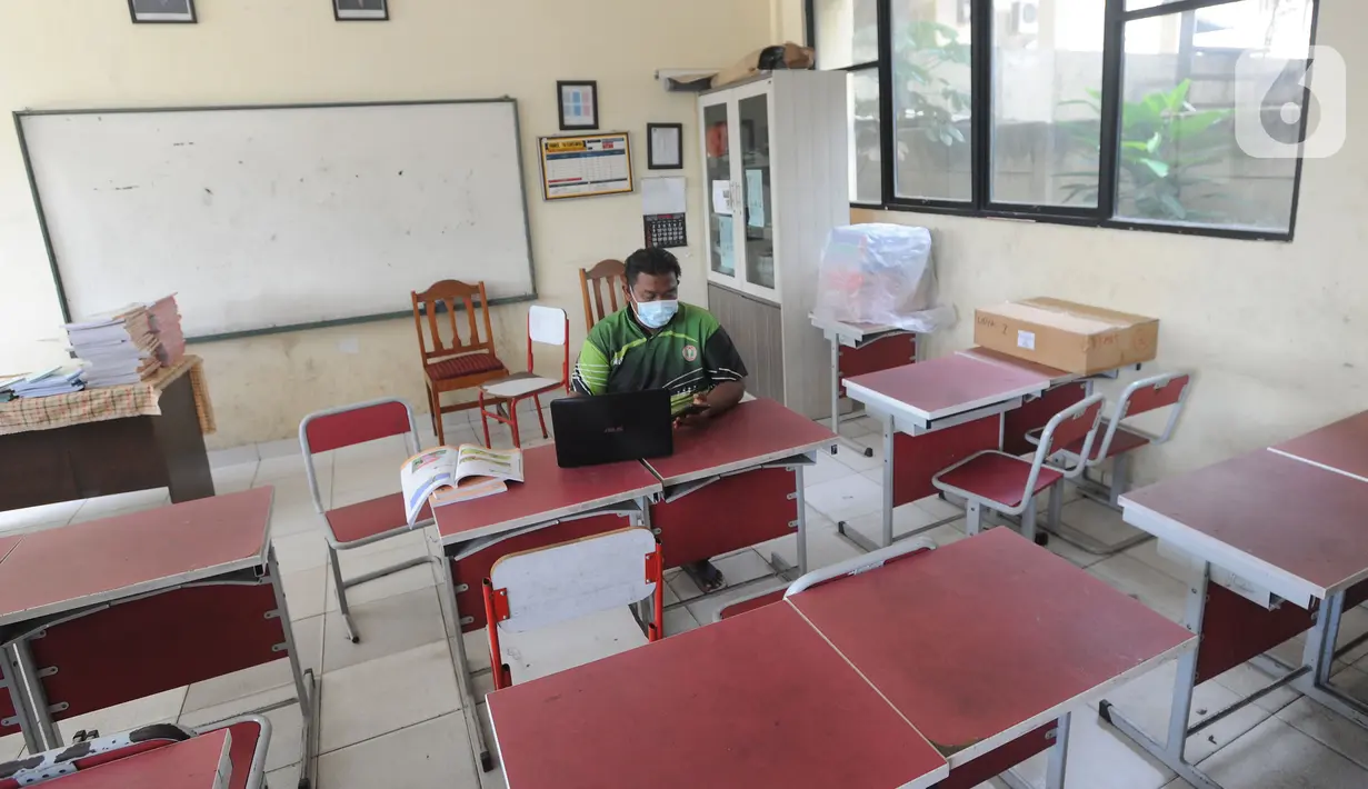 Guru mengajar mata pelajaran olah raga secara darling pada sebuah kelas kosong di SDN Pondok Cabe Udik 01, Pamulang, Tangerang Selatan, Jumat (8/1/2020). Rencana kegiatan belajar tatap muka pada awal Januari di wilayah Tangsel dibatalkan. (merdeka.com/Arie Basuki)