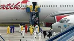 Sejumlah Warga Negara Indonesia (WNI) yang dievakuasi dari Wuhan, China keluar dari pesawat  Batik Air di bandara internasional Hang Nadim, Batam, Minggu (2/2/2020). Sebanyak 245 WNI di Wuhan akan dievakuasi ke Indonesia terkait merebaknya virus corona di kota tersebut. (AFP/Ricky Prakoso)