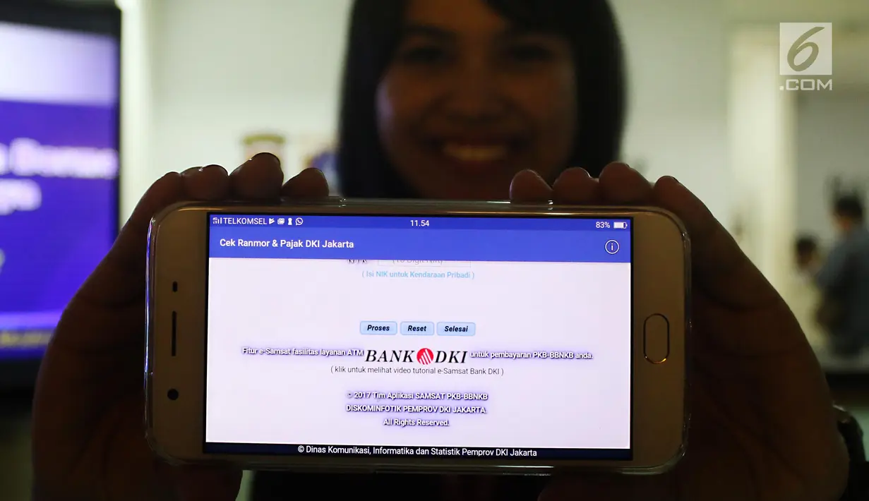 Seorang wanita menunjukkan tampilan dari aplikasi Informasi data dan pajak kendaraan di ponsel saat peluncuran di Samsat DKI Polda Metro Jaya, Jakarta, Rabu (21/6). (Liputan6.com/Angga Yuniar)
