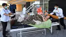 Seorang ibu korban gempa Lombok menjalani perawatan di luar Rumah sakit Moh. Ruslan di Mataram,  Senin (6/8). Berdasarkan laporan sementara yang diterima BPBD NTB, korban meninggal akibat gempa Lombok sudah mencapai 89 orang. (AFP/ADEK BERRY)