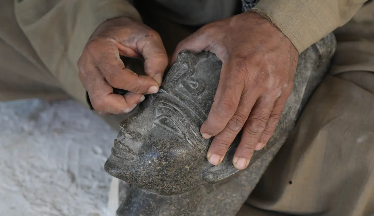 Seorang pemahat bekerja di sebuah bengkel kerajinan alabaster atau sejenis batu pualam di Desa Gurna, Luxor, Mesir, 17 Desember 2020. Desa Gurna terkenal sebagai penghasil kerajinan tangan dan suvenir bergaya Mesir kuno yang dibuat dari pahatan alabaster. (Xinhua/Ahmed Gomaa)