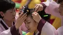 Seorang pelajar mempersiapkan diri sebelum mengikuti upacara Coming of Age Day di Namsan Hanok Village, Seoul, Senin (15/5). Upacara Hari Kedewasaan adalah hari libur resmi untuk menghormati siapa saja yang baru menginjak usia 20 tahun. (Ed JONES/AFP)