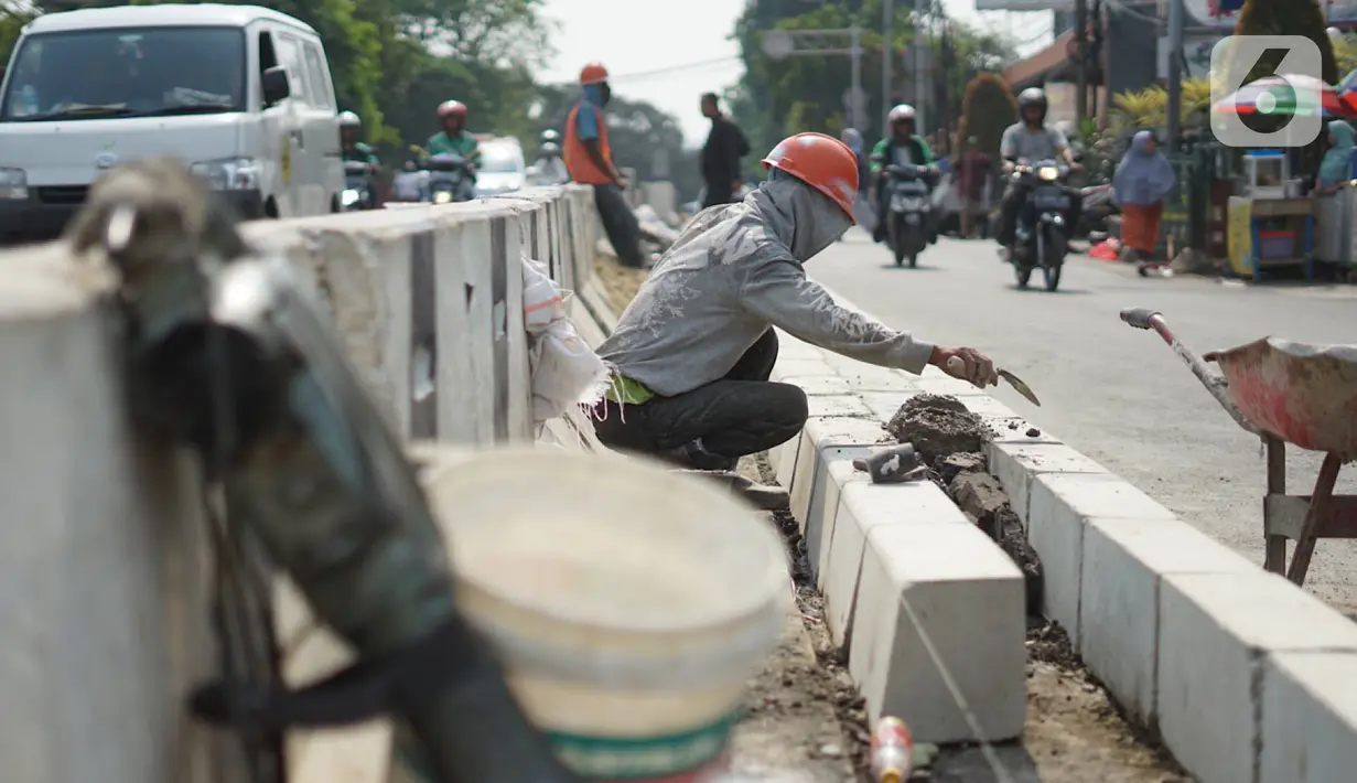 Pekerja menyelesaikan pembuatan separator jalan di kawasan Pasar Minggu, Jakarta Selatan, Rabu (23/10/2019). Pembuatan separator permanen tersebut merupakan bagian dari penataan kawasan Pasar Minggu agar lebih tertata dengan rapi. (Liputan6.com/Immanuel Antonius)