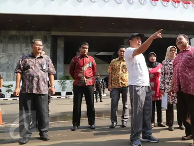 Ketua DPR RI Ade Komarudin (topi) berbincang ketika meninjau persiapan Pidato Kenegaraan di Gedung Nusantara, komplek Parlemen, Jakarta, Jumat (12/8). Saat melakukan peninjauan, Akom didampingi Sekjen DPR dan jajarannya. (Liputan6.com/Angga Yuniar)